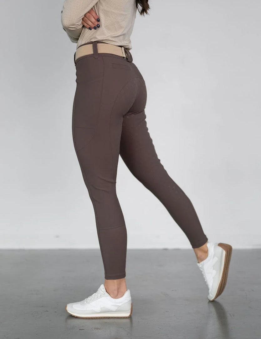 Side view of a model wearing the brown Free Ride PRO Full Seat Breeches on a plain background