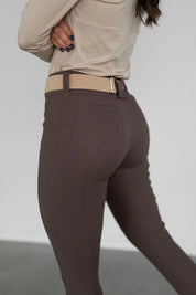 Close-up side view of a model wearing the brown Free Ride PRO Full Seat Breeches on a plain background