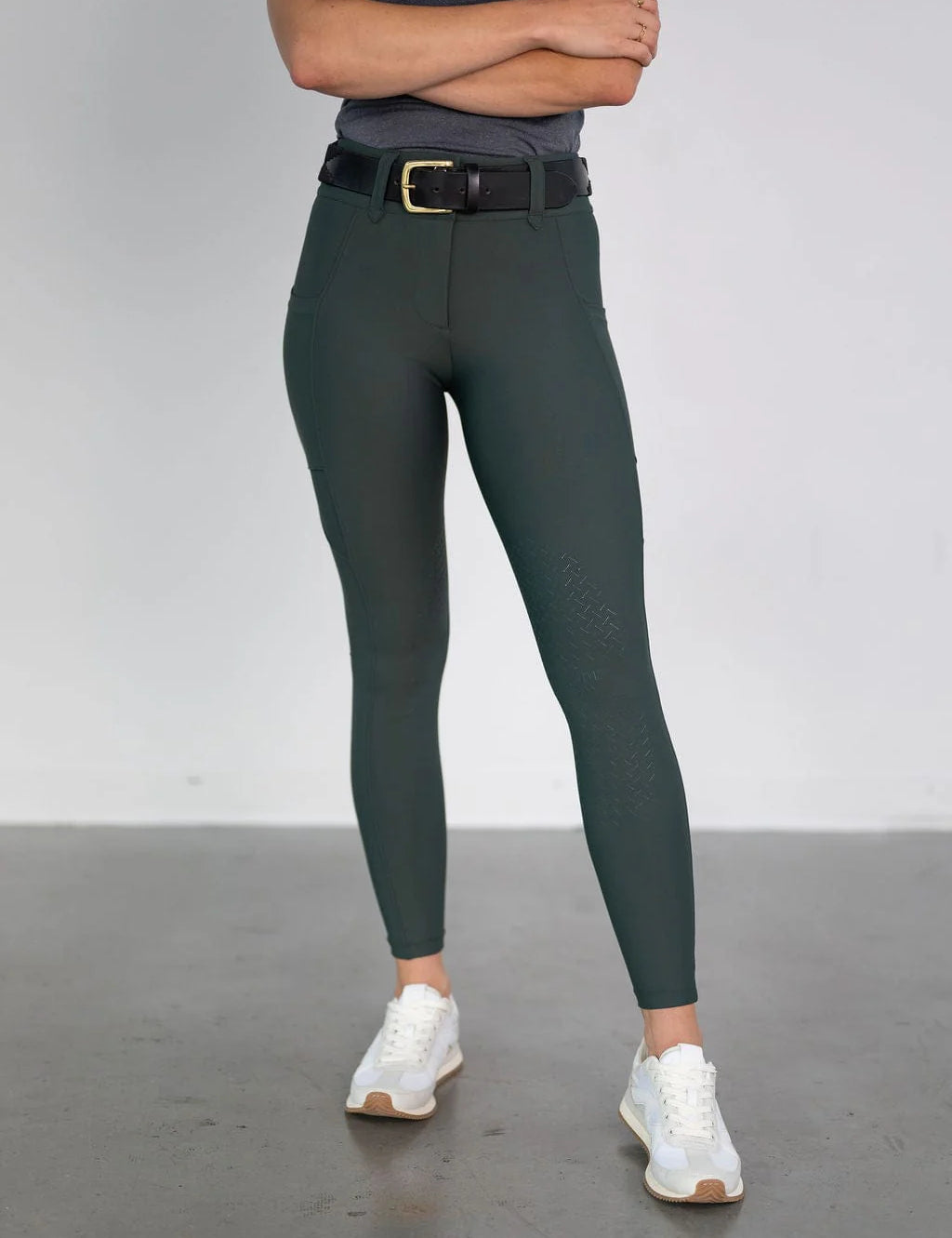 Front view of a female model wearing the green Free Ride Lux Knee Patch Breeches in a studio setting
