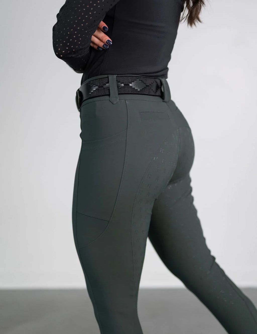 Side view of a model wearing the green Free Ride PRO Full Seat Breeches on a plain background