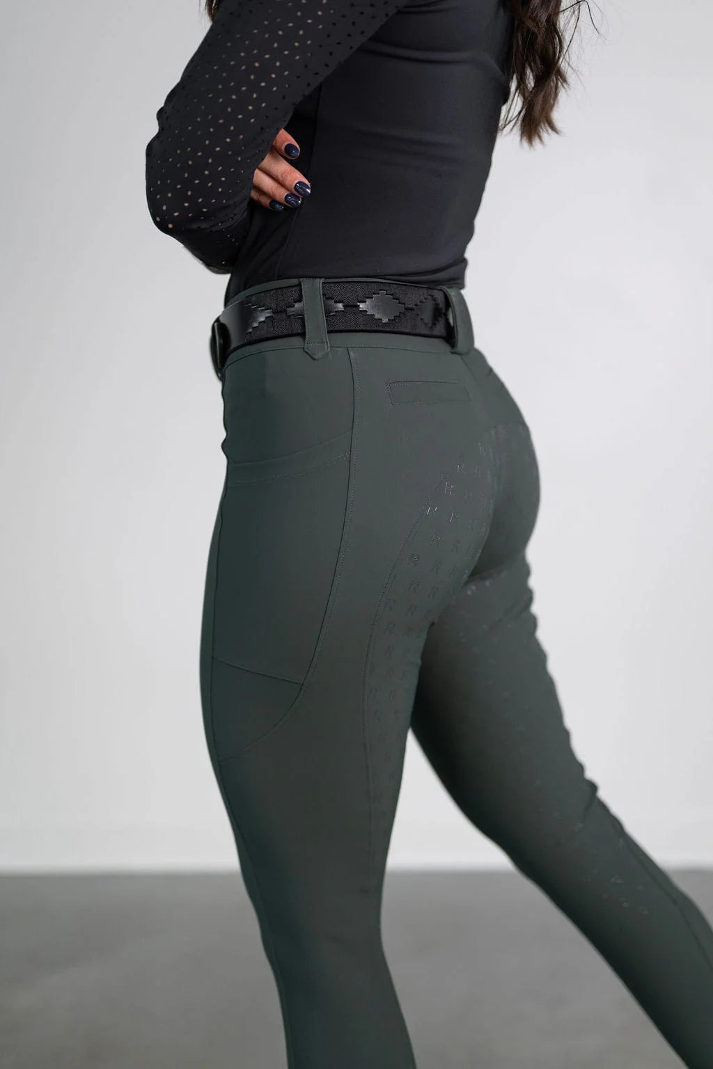 Side view of a model wearing the green Free Ride PRO Full Seat Breeches on a plain background