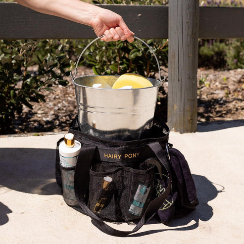 View of someone putting a metal bucket into the center of a Hairy Pony Horse Wash Bay Bag