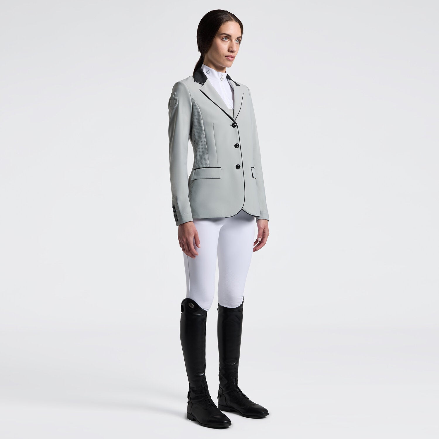 Angled front view of a female model wearing the gray Cavalleria Toscana GP Perforated Riding Jacket on a plain background