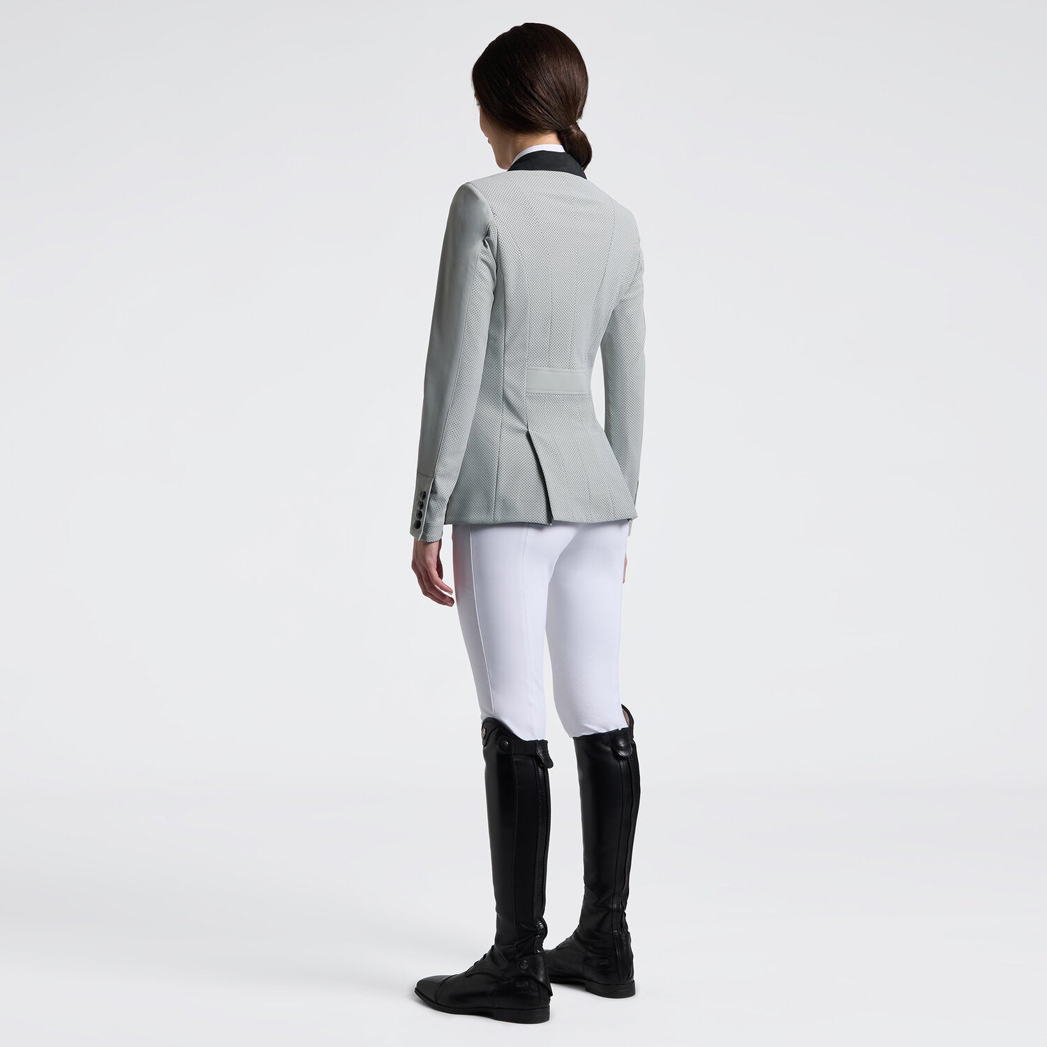 Angled back view of a female model wearing the gray Cavalleria Toscana GP Perforated Riding Jacket on a plain background