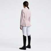Full body angled back view of a female model wearing the pink Cavalleria Toscana Raw Cut Competition Jacket and white breeches on a plain background
