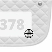 Side view of a white pad with numbers 378 and a Go Fast Jump Clear Dubois Cheval Number Pin Charm on a white background