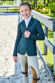 Outdoor photo of the RJ Classics Harmony Jr. 2.0 Mesh Show Coat in Green Gables, showing a notched lapel, three-button front, and mesh sleeves and side panels, worn over a white high-collar show shirt with tan knee-patch breeches.