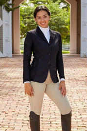 Front view of a female model wearing the black RJ Classics Harmony Mesh Coat while standing outside on a brick bath