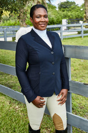 Front view of a female model wearing the navy RJ Classics Harmony Mesh Coat while standing outside in front of a fence