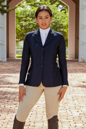Front view of a female model wearing the navy RJ Classics Harmony Mesh Coat while standing outside on a brick bath