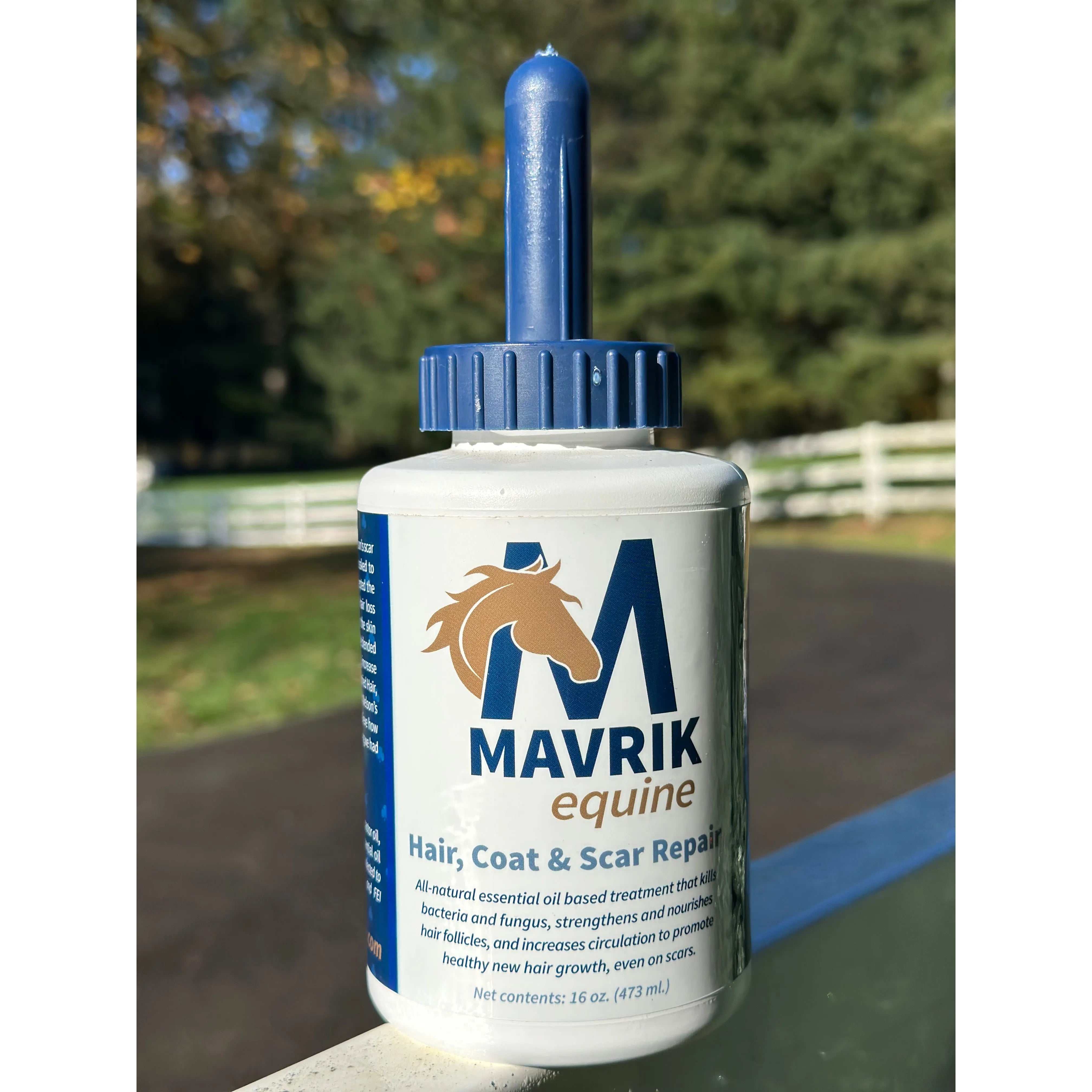 Front view of a 16 oz bottle of Mavrik Equine Hair, Coat & Scar Repair on a fence outside