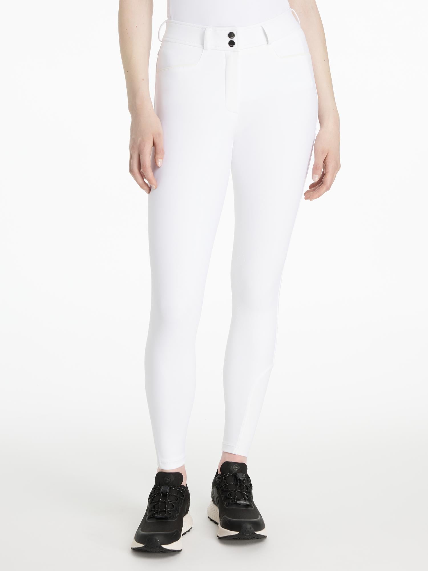 Model wearing LeMieux Isabelle Full Seat Breeches in White with black athletic shoes