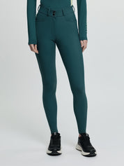 Model wearing LeMieux Isabelle Full Seat Breeches in green with high-rise waistband and black athletic shoes
