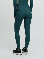 Model wearing LeMieux Isabelle Full Seat Breeches in Jungle, back view with full seat grip and black athletic shoes