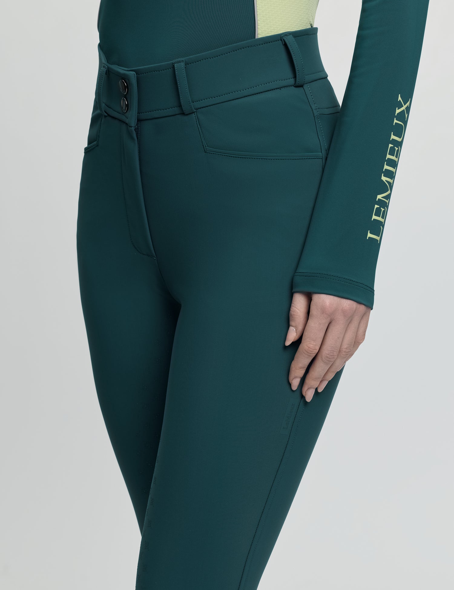 Close-up of LeMieux Isabelle Full Seat Breeches in jungle green showing waistband, belt loops, and front pocket
