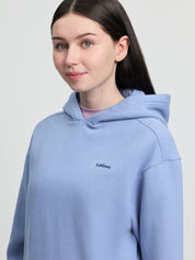 Close-up of model wearing LeMieux Young Rider Sia Hoodie in powder blue showing hood and LeMieux chest logo