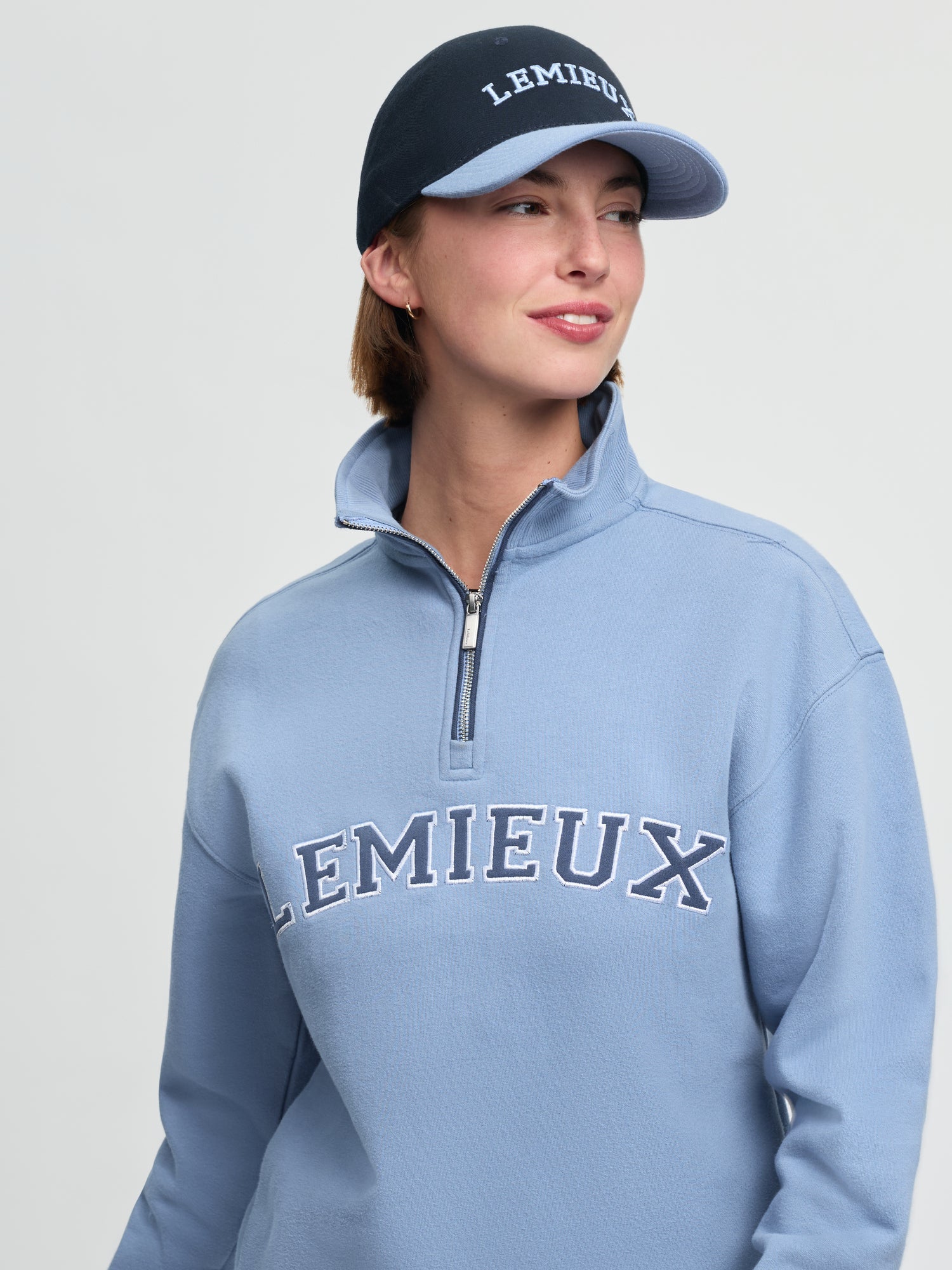 Model wearing LeMieux Ashley Cap in Shadow with embroidered LeMieux logo and contrasting curved brim
