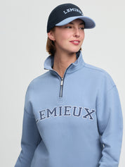 Model wearing LeMieux Ashley Cap in Shadow with embroidered LeMieux logo and contrasting curved brim