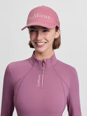 Model wearing LeMieux Lara Cap in Mallow with LeMieux logo on front and curved brim