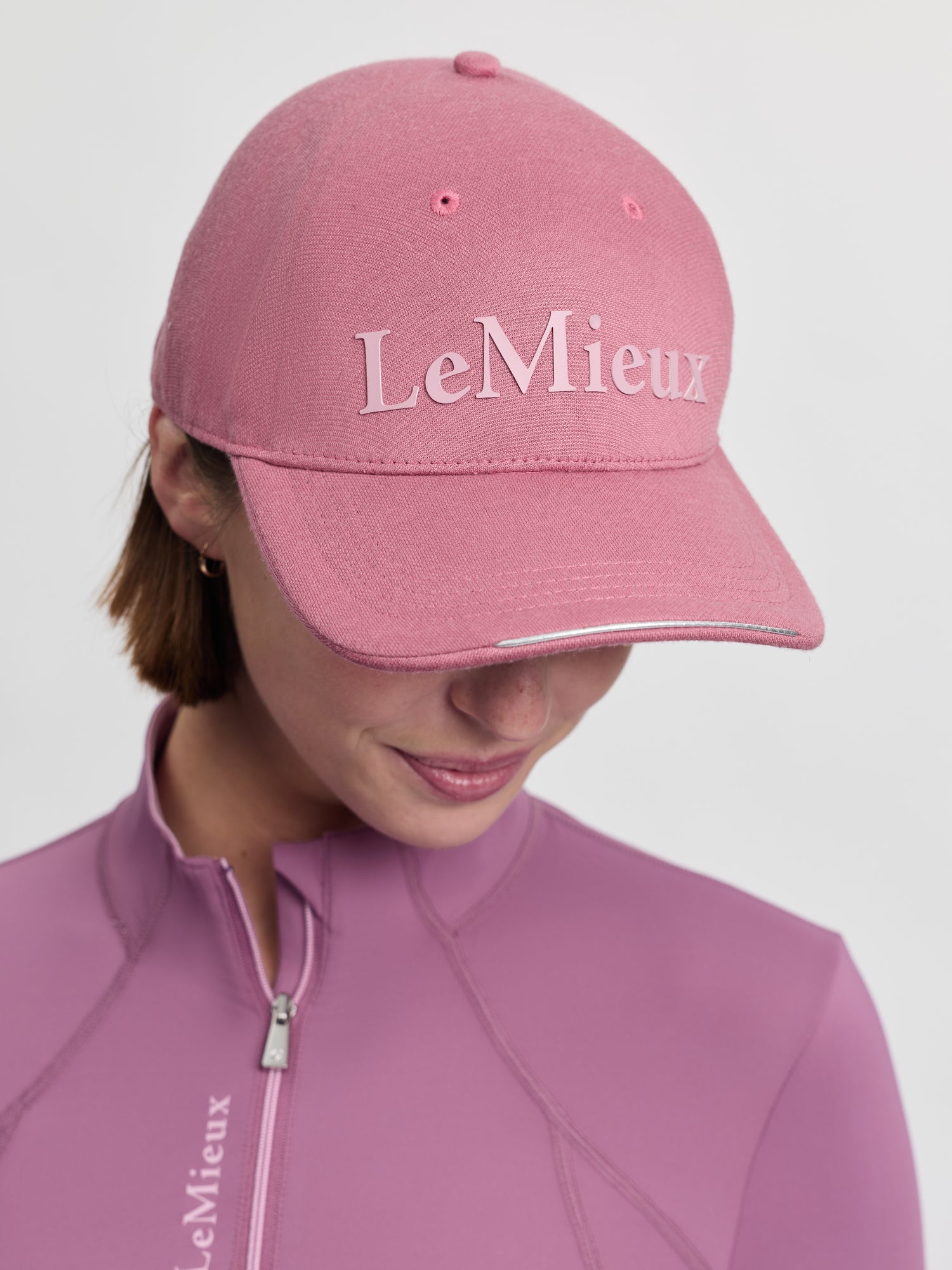 Model wearing LeMieux Lara Cap in Mallow with LeMieux logo on front and curved brim