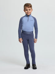 Child wearing LeMieux Mini Pull On Breech in Shadow with elastic logo waistband and silicone grip print on inner legs