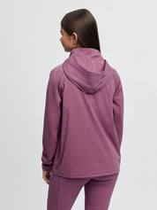 Back view of model wearing LeMieux Young Rider Paige Quarter Zip Waterproof Jacket in Mallow showing attached hood