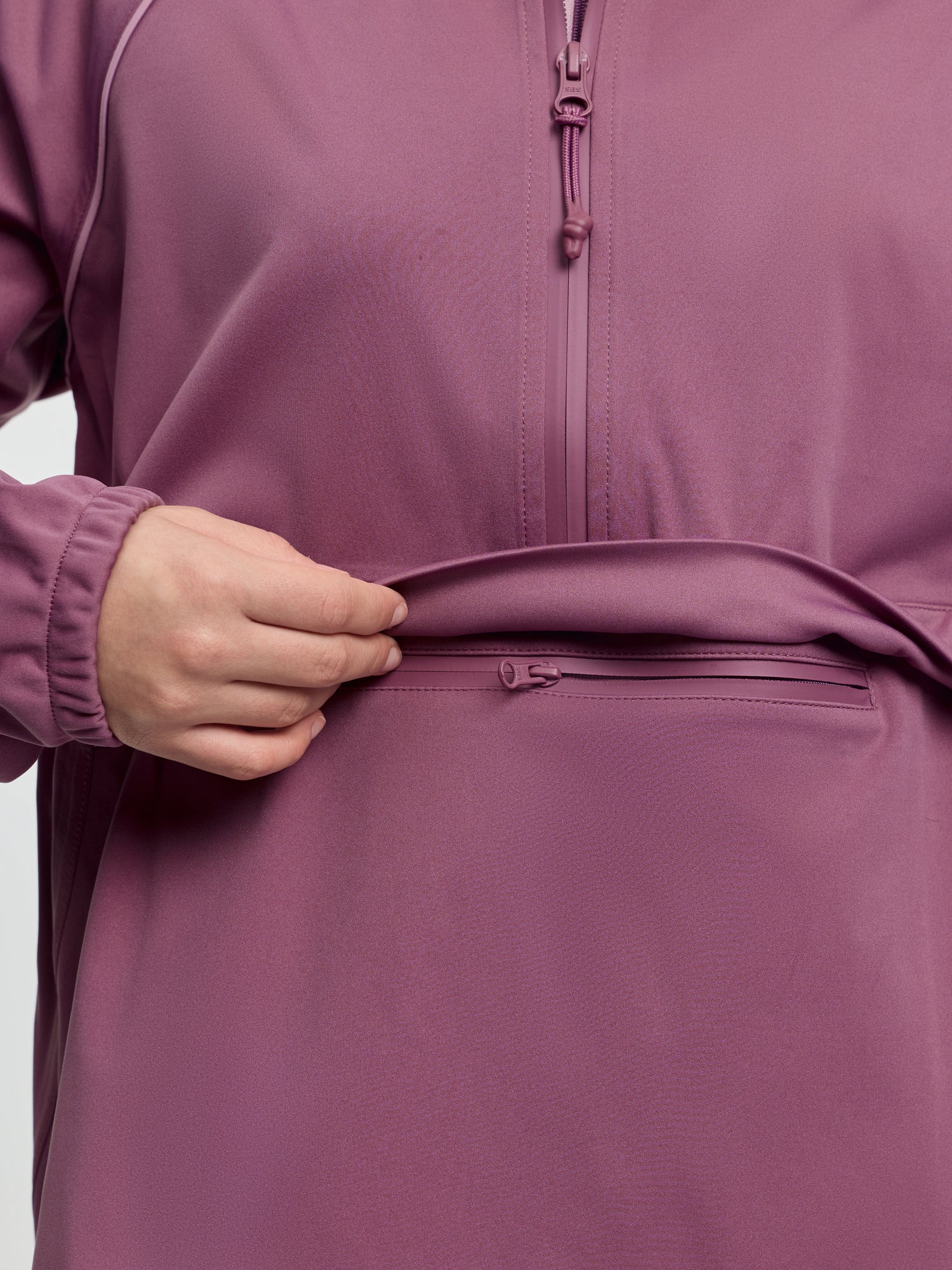Close-up of LeMieux Young Rider Paige Quarter Zip Waterproof Jacket in Mallow showing quarter zip and front zip pocket
