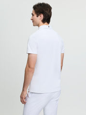 Back view of model wearing LeMieux men’s short sleeve competition shirt in white with button collar