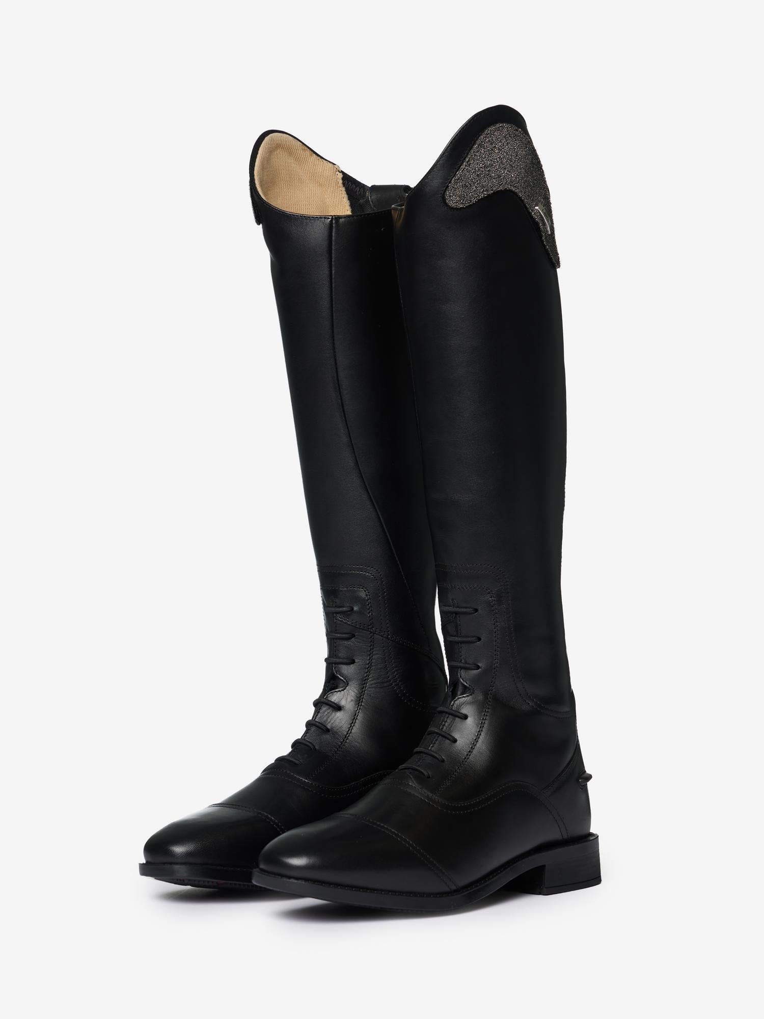 Angled view of a pair of LeMieux Junior Interchangeable Riding Boots in Black with laces on the front of the ankle