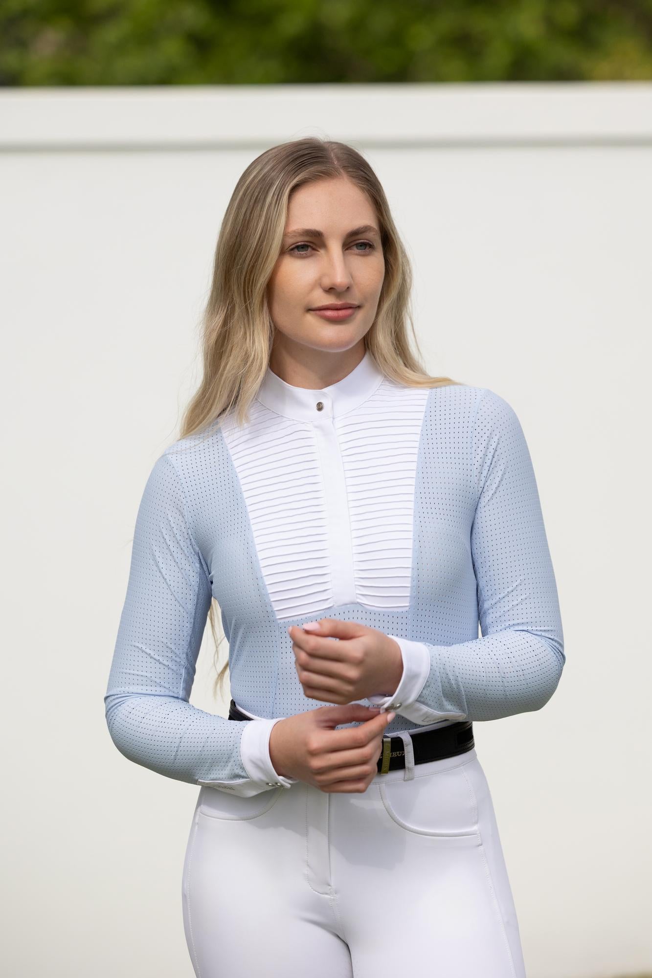 Model wearing LeMieux Arielle Long Sleeve Show Shirt in Mist with white stand collar, pleated bib front, and white cuffs