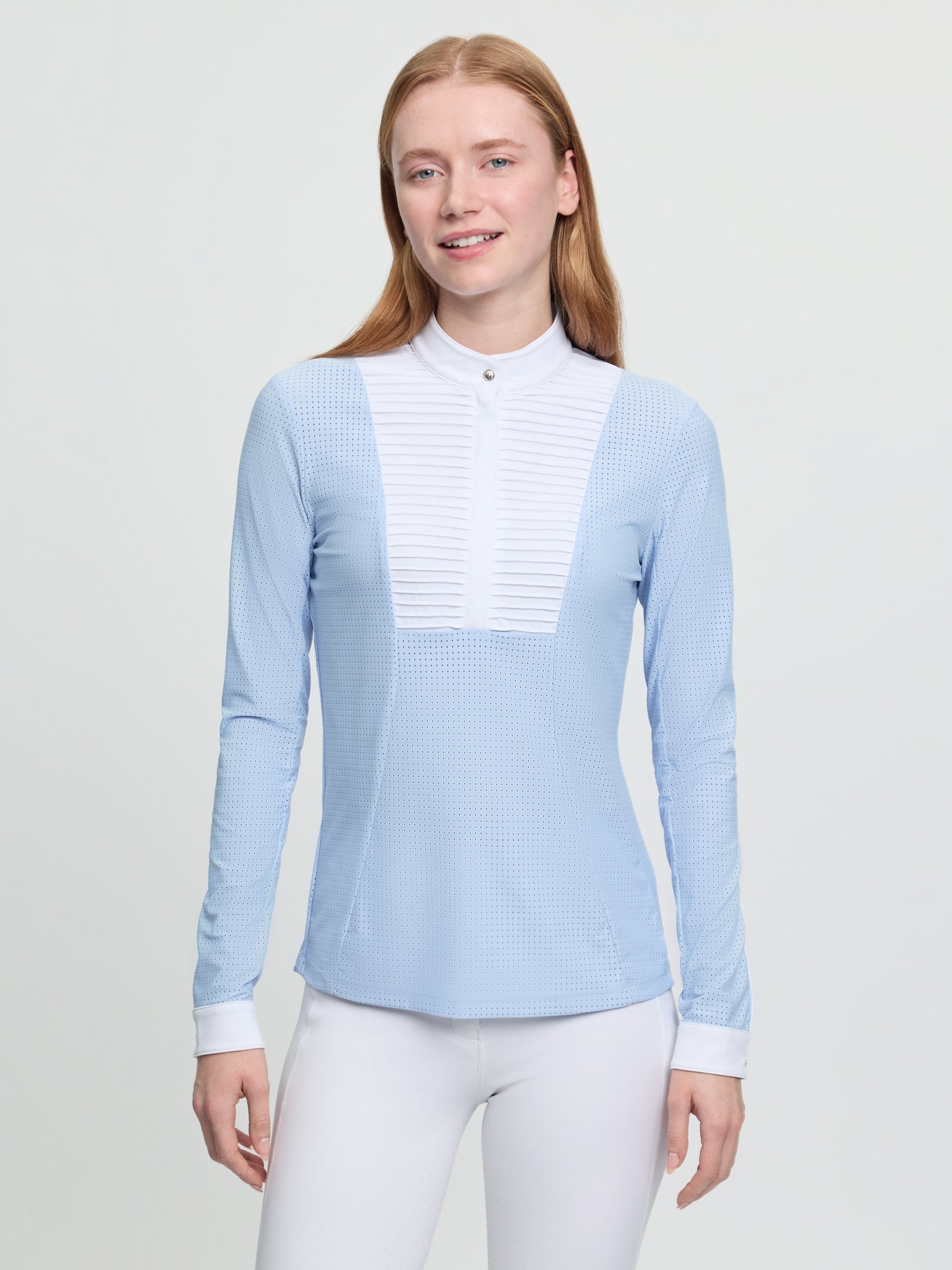 Model wearing LeMieux Arielle Long Sleeve Show Shirt in Mist with white stand collar and pleated bib front
