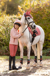 Front view of a young female model wearing Petal LeMieux Mini Maggie Heart Fleece and standing outdoors