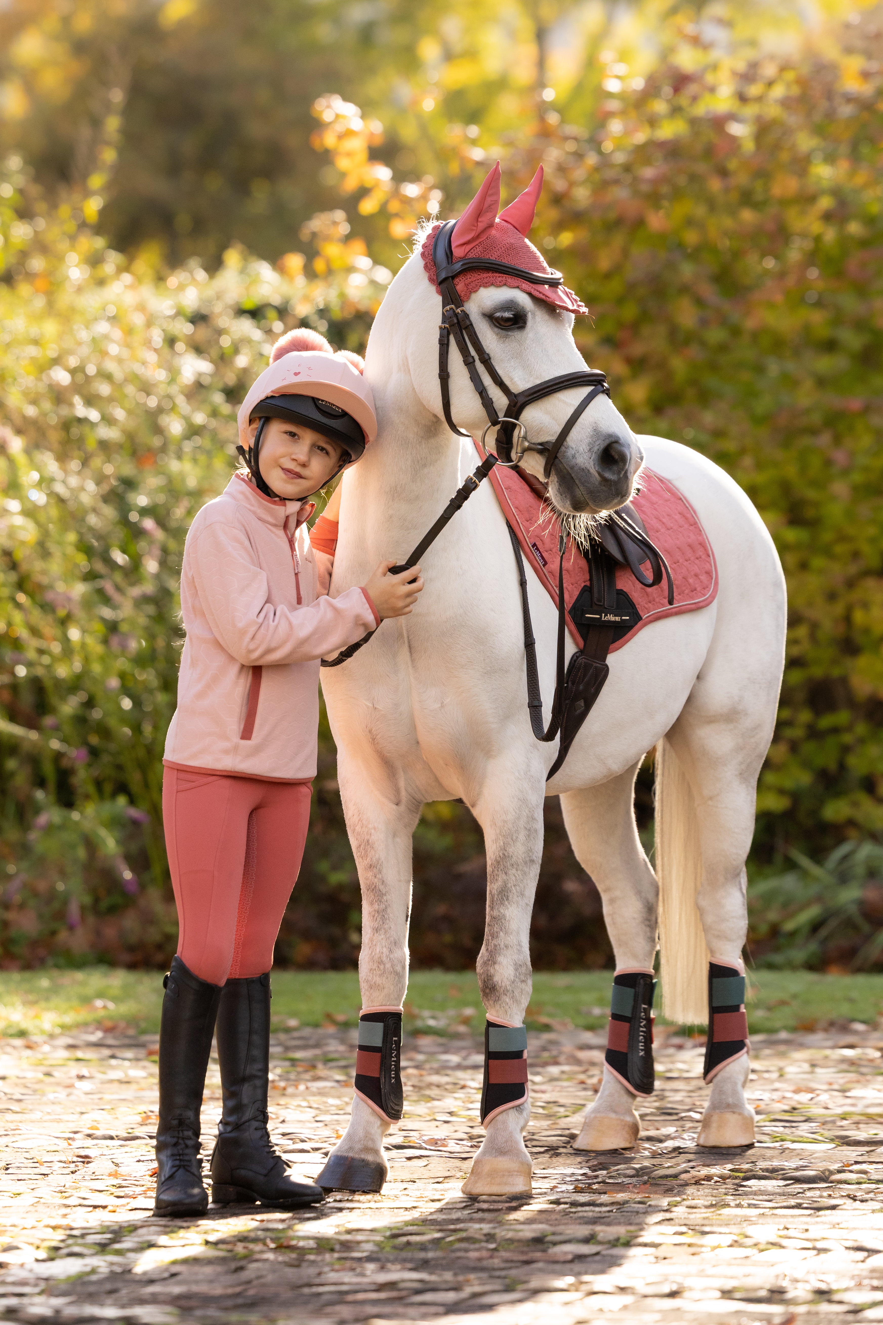 Front view of a young female model wearing Petal LeMieux Mini Maggie Heart Fleece and standing outdoors