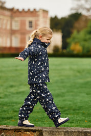 Front view of a young female model wearing Navy LeMieux Mini Pippin Splash Jacket and walking outdoors