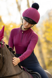 Front view of a model wearing Blackberry LeMieux Young Rider Classique Base Layer while riding a horse