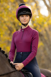 Front view of a model wearing Blackberry LeMieux Young Rider Classique Base Layer while riding a horse