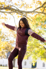 Angled front view of a young female model wearing Bramble LeMieux Young Rider Viola Quarter Zip Sweatshirt outdoors