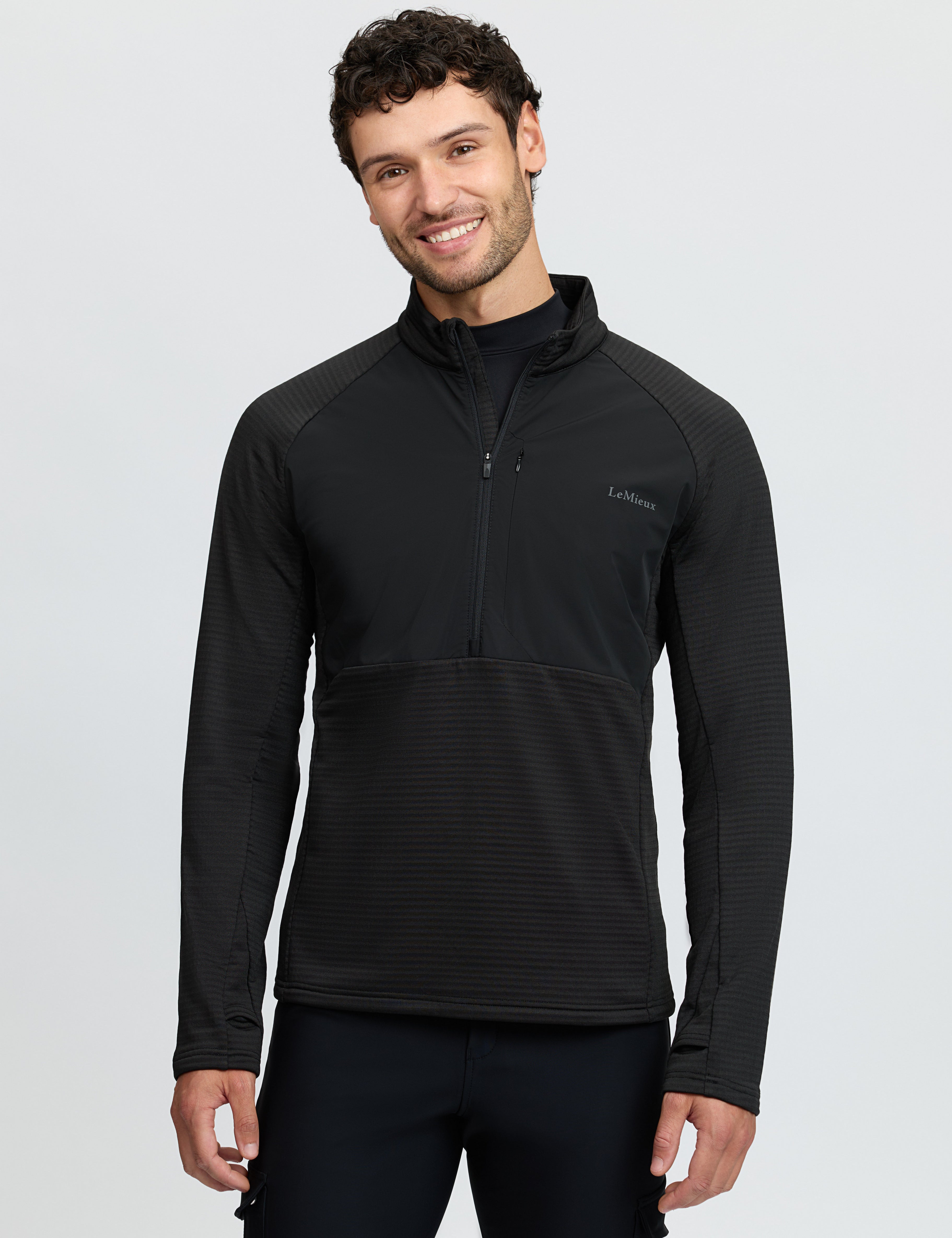 Front view of a model wearing the Black LeMieux Men's Quarter Zip Mid Layer on a white background