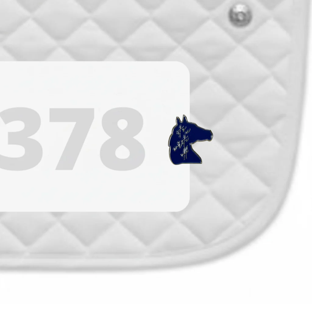 Side view of a white pad with numbers 378 and an "It's A Write Off" Dubois Cheval Number Pin Charm on a white background