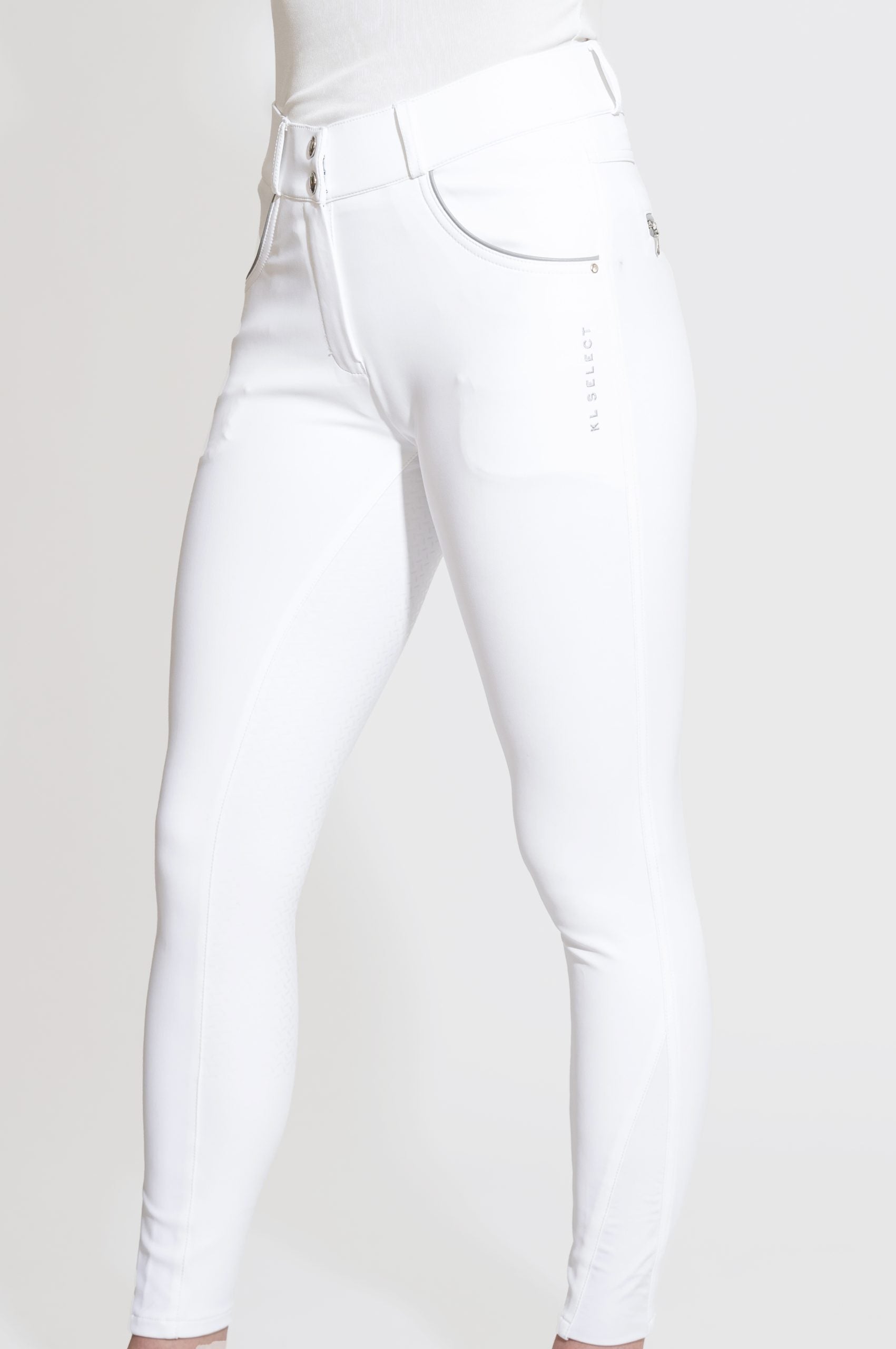 Side view of a model wearing the white KL Select Gabrielle Full Seat Breech on a white background