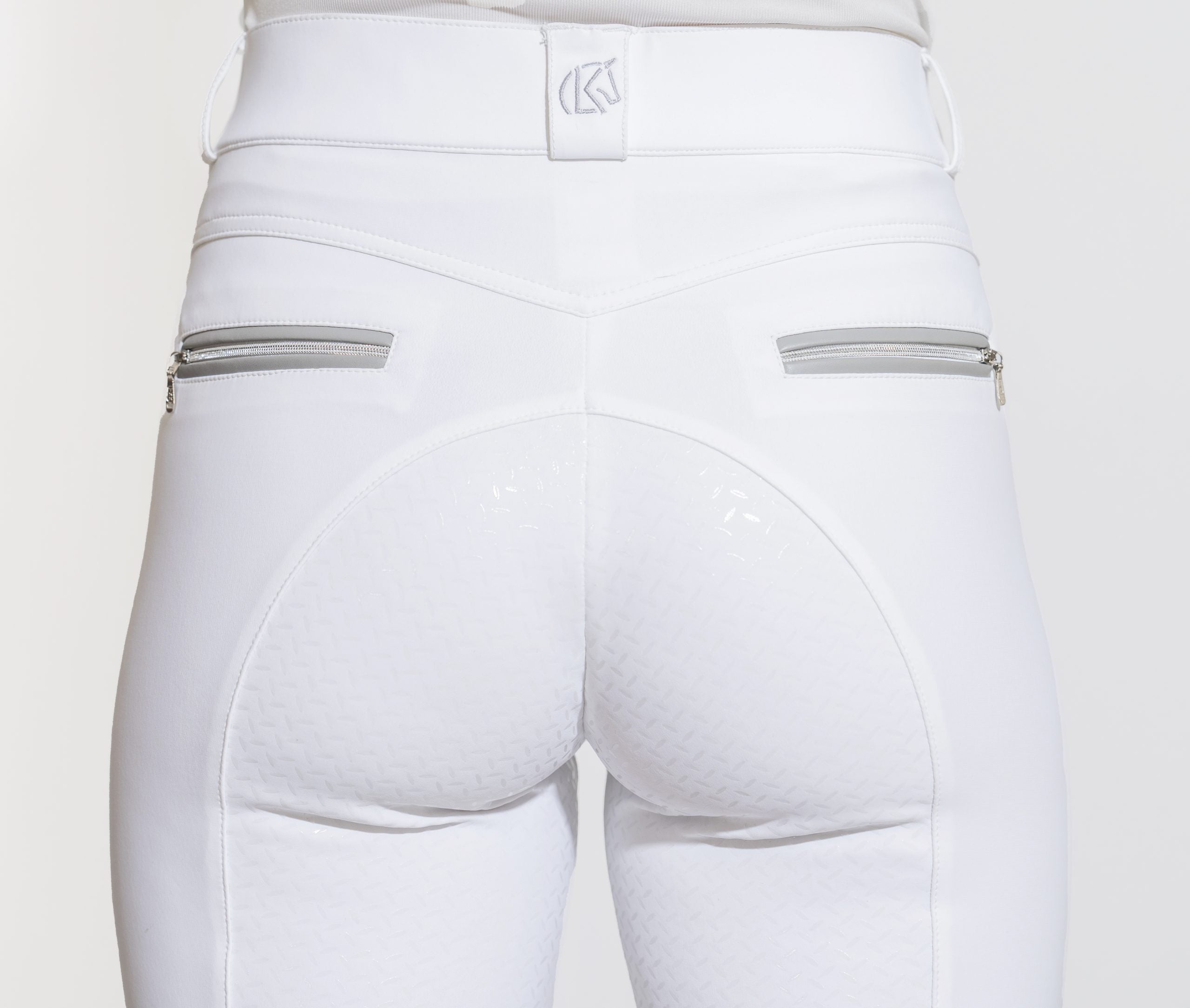 Close-up back view of a model wearing the white KL Select Gabrielle Full Seat Breech on a white background