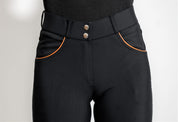 Close-up front view of a model wearing the black/cognac KL Select Gabrielle Knee Patch Breech on a plain background
