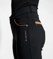 Close-up side view of a model wearing the black/cognac KL Select Gabrielle Knee Patch Breech on a plain background
