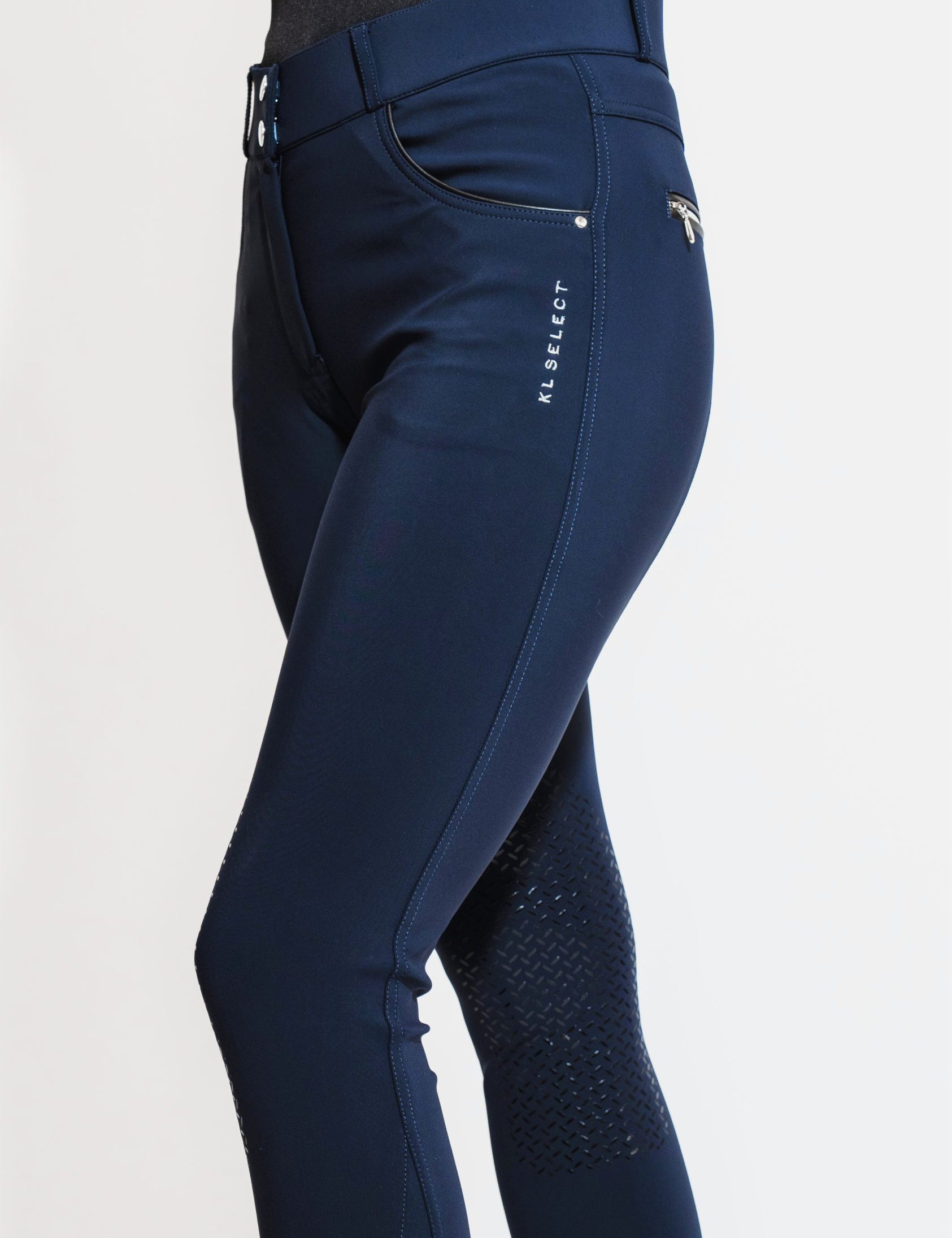 Angled side view of a model wearing the navy KL Select Gabrielle Knee Patch Breech on a plain background