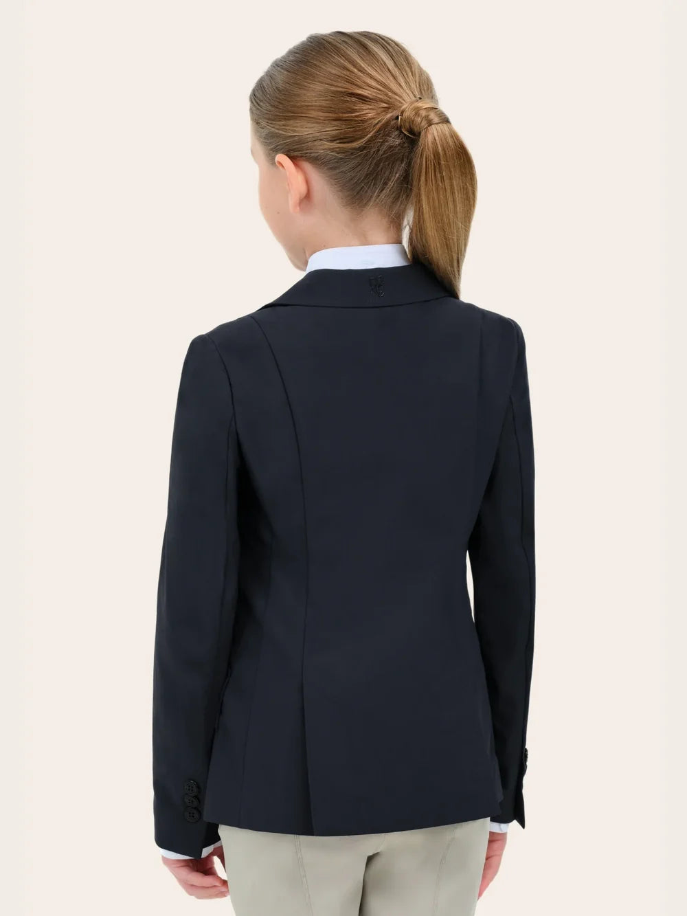 Back view of a young female model wearing the black RJ Classics Legacy Lite Jr Show Coat on a plain background