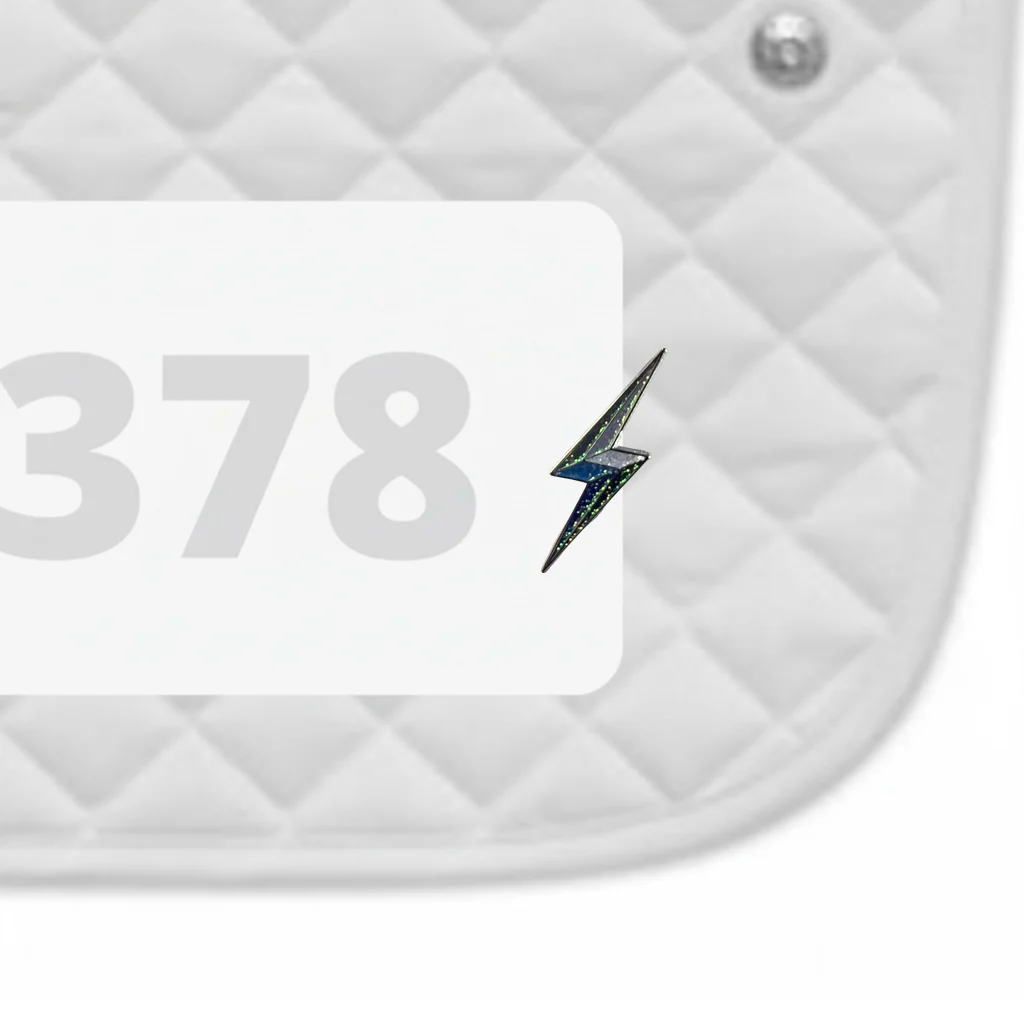 Side view of a white pad with numbers 378 and a Lightning Bolt Dubois Cheval Number Pin Charm on a white background