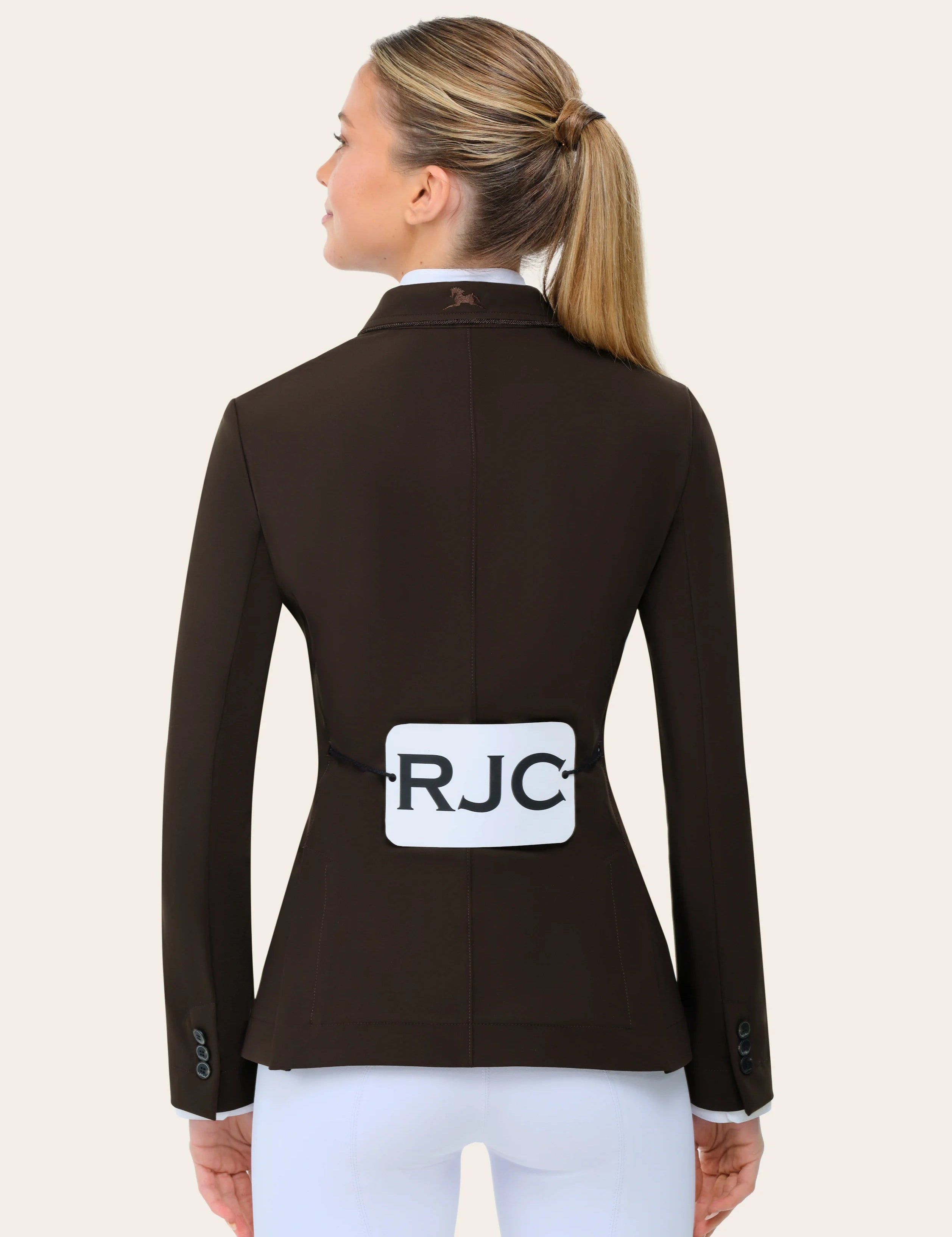 Back view of a female model wearing the chocolate RJ Classics Monterey Show Coat on a plain background