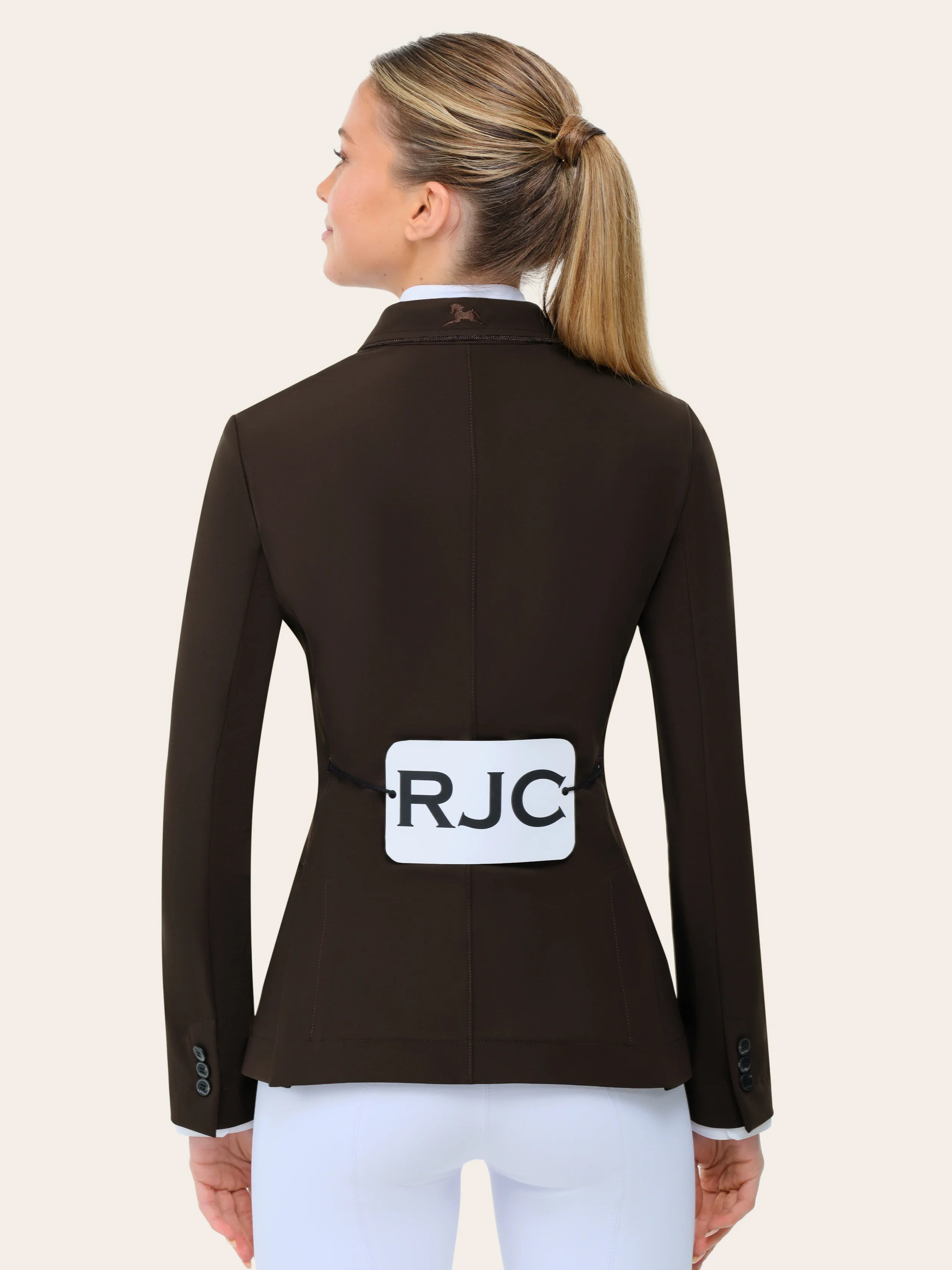 Back view of a female model wearing the chocolate RJ Classics Monterey Show Coat on a plain background