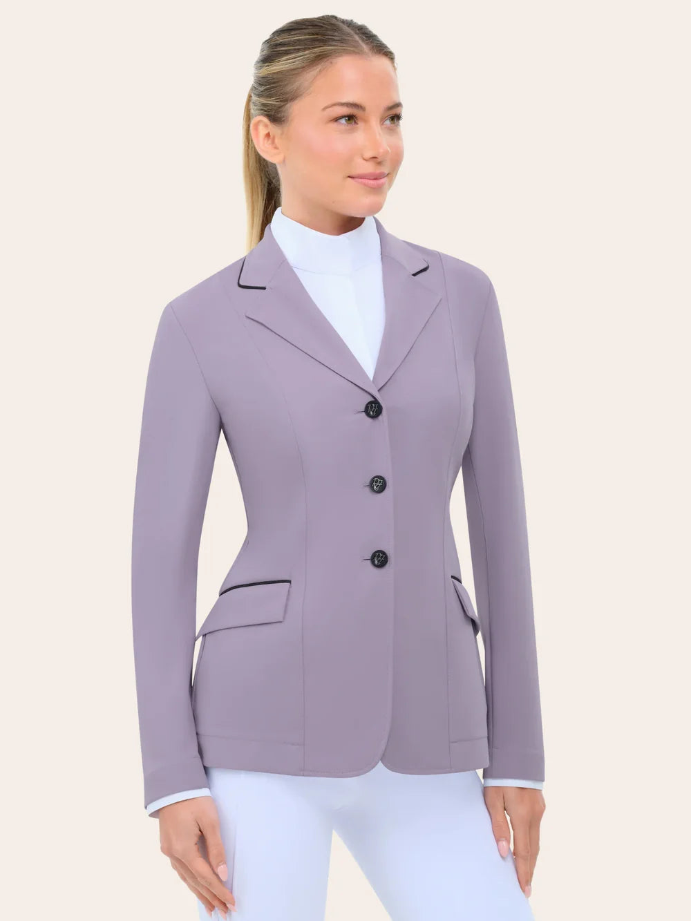 Front view of the RJ Classics Monterey Show Coat Eleganza Edition in Dusty Lilac, a fitted equestrian show jacket with black collar piping, three-button front closure, and flap pockets with contrast piping, shown over a white high-collar show shirt and white riding breeches against a plain light background.