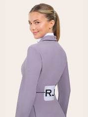 Angled back view of the RJ Classics Monterey Show Coat Eleganza Edition in Dusty Lilac, showing the fitted silhouette, black collar piping, and subtle RJ logo branding on the sleeve, photographed over a white show shirt on a model against a plain light background.
